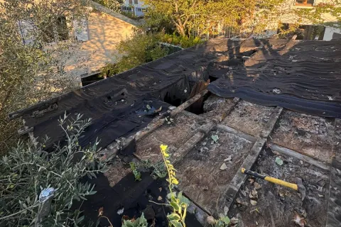 Ancienne couverture en membrane noire percée et bois à nu sur un garage au Mesnil-le-Roi (78), avant les travaux