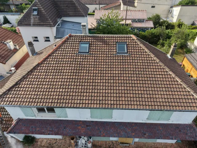 Couvreur réparant une toiture en tuiles à Colombes (92)