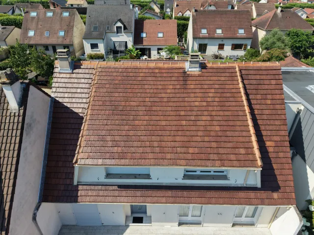 Couvreur travaillant sur une toiture en ardoise à Versailles (78)