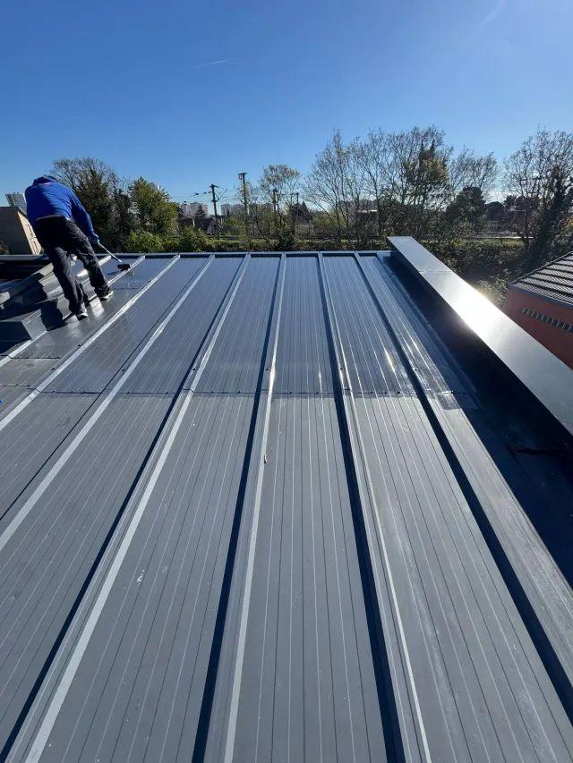 Couvreur posant une membrane d’étanchéité sur un toit-terrasse à Houilles