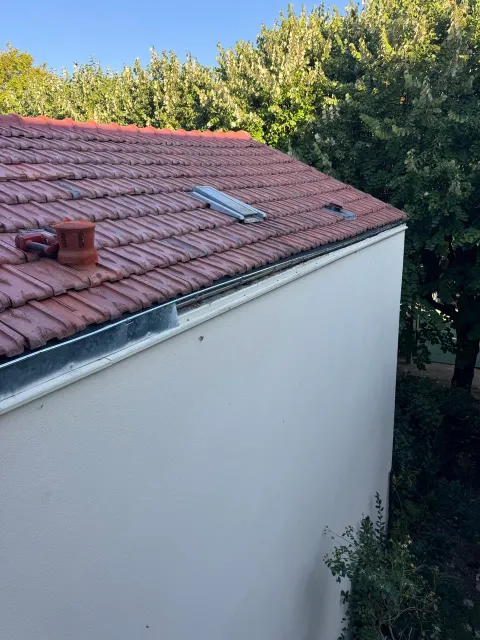 Gouttière et zinguerie neuves posées sur une toiture en tuiles en Île-de-France