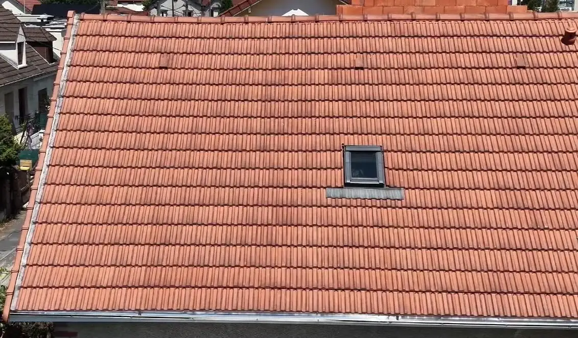 Couvreur en intervention sur un faîtage de toiture en tuiles en Île-de-France